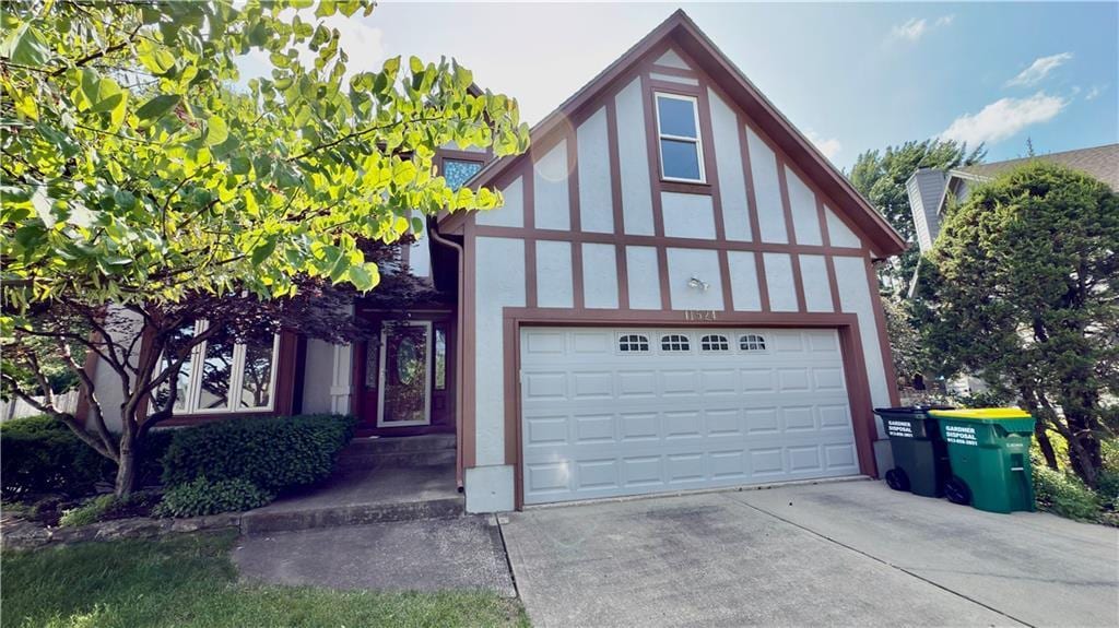 11524 Flint St, Overland Park, KS 66210 - tudor-style house featuring driveway, a garage, and stucco siding