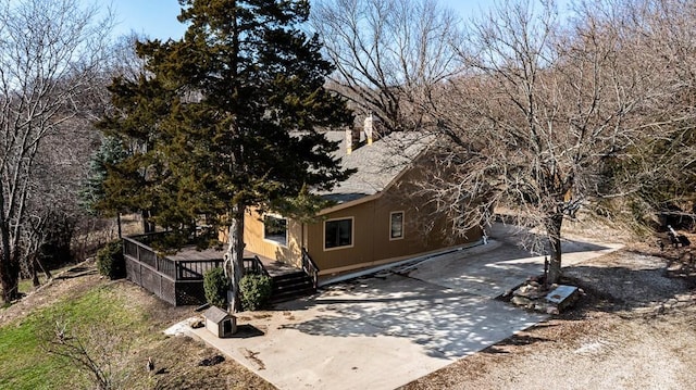 22450 Hatchell Rd, Tonganoxie, KS 66086 - view of front facade with a deck, concrete driveway, and a shingled roof