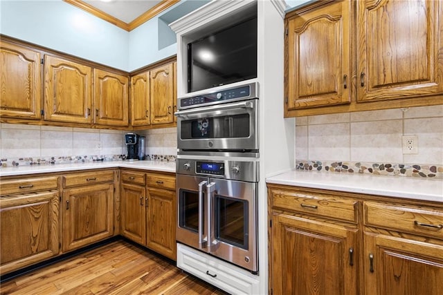 13008 Fontana St, Leawood, KS 66209 - kitchen with brown cabinetry, tasteful backsplash, crown molding, and stainless steel double oven