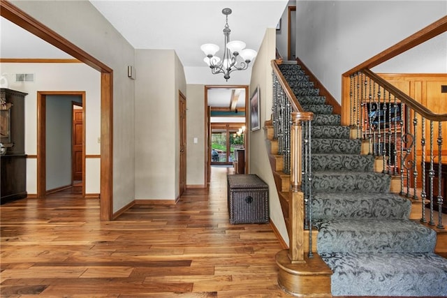 13008 Fontana St, Leawood, KS 66209 - stairway featuring wood finished floors and a chandelier