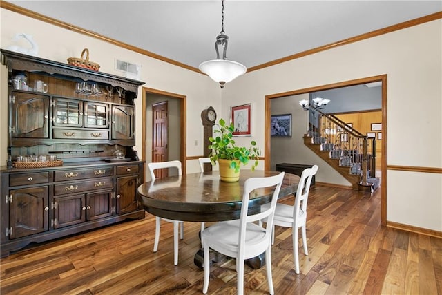 13008 Fontana St, Leawood, KS 66209 - dining area featuring wood finished floors, ornamental molding, a chandelier, and stairway