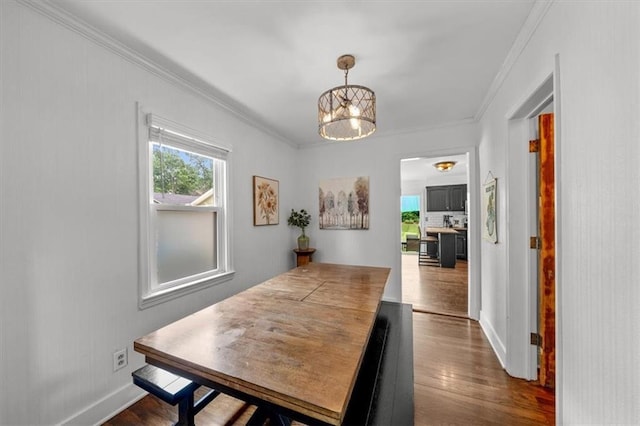 5741 Hadley St, Merriam, KS 66202 - dining area featuring dark wood-type flooring, a chandelier, crown molding, and baseboards