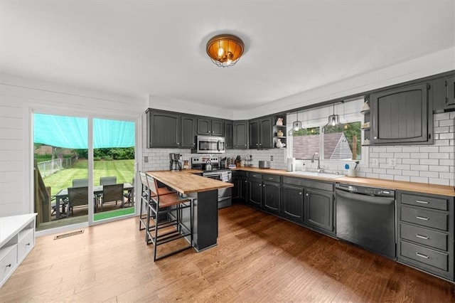5741 Hadley St, Merriam, KS 66202 - kitchen featuring stainless steel appliances, wood counters, a sink, and decorative backsplash