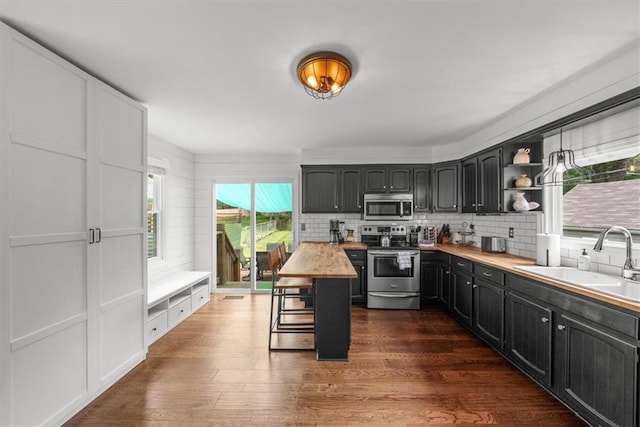 5741 Hadley St, Merriam, KS 66202 - kitchen featuring appliances with stainless steel finishes, a sink, butcher block counters, backsplash, and open shelves
