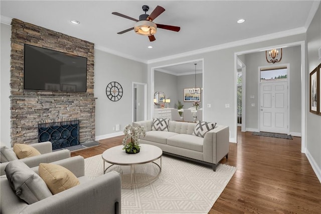12428 Cambridge Cir, Leawood, KS 66209 - living area with a chandelier, a ceiling fan, wood finished floors, a stone fireplace, and ornamental molding