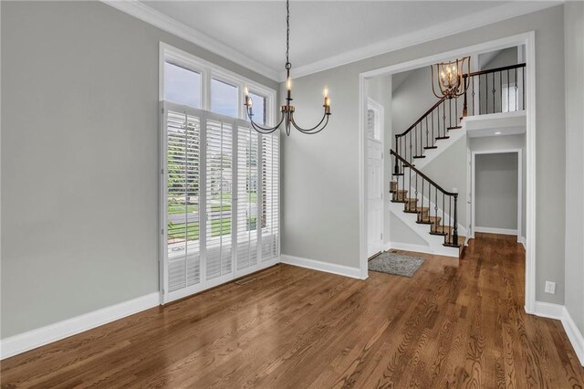 12428 Cambridge Cir, Leawood, KS 66209 - unfurnished dining area with a chandelier, stairway, crown molding, wood finished floors, and baseboards