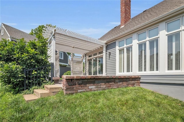 12428 Cambridge Cir, Leawood, KS 66209 - rear view of house with a chimney, a pergola, and a lawn