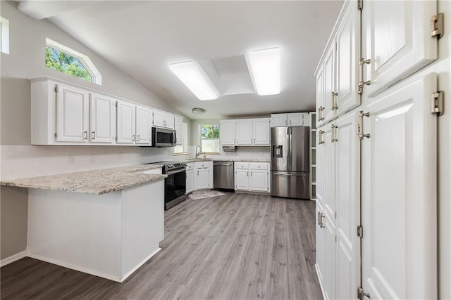 3906 Oo Hwy, Odessa, MO 64076 - kitchen featuring appliances with stainless steel finishes, light wood-type flooring, a sink, a peninsula, and white cabinets