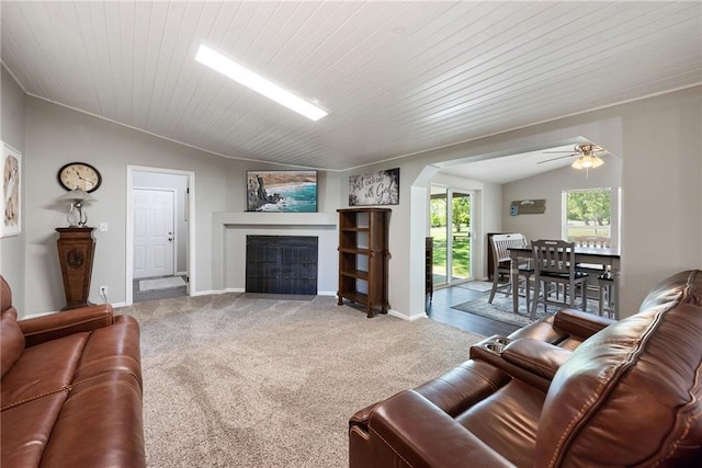3906 Oo Hwy, Odessa, MO 64076 - carpeted living room with vaulted ceiling, arched walkways, a fireplace with flush hearth, a ceiling fan, and baseboards