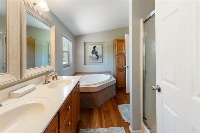 3906 Oo Hwy, Odessa, MO 64076 - bathroom featuring wood finished floors, a shower stall, a bath, double vanity, and vaulted ceiling