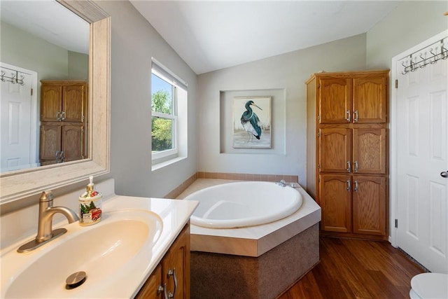 3906 Oo Hwy, Odessa, MO 64076 - bathroom with lofted ceiling, a garden tub, wood finished floors, vanity, and toilet