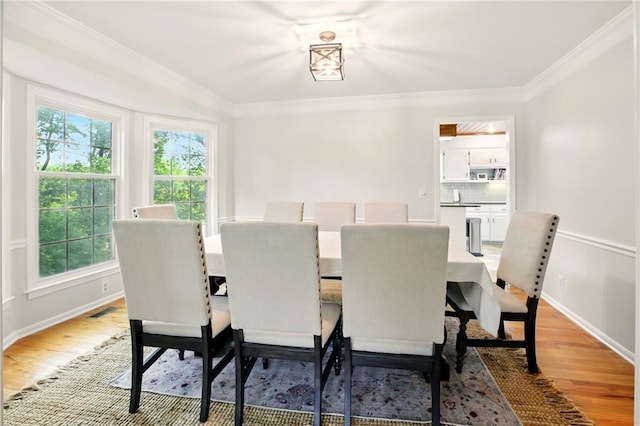 12844 Granada Ln, Leawood, KS 66209 - dining room featuring plenty of natural light, light wood finished floors, and crown molding