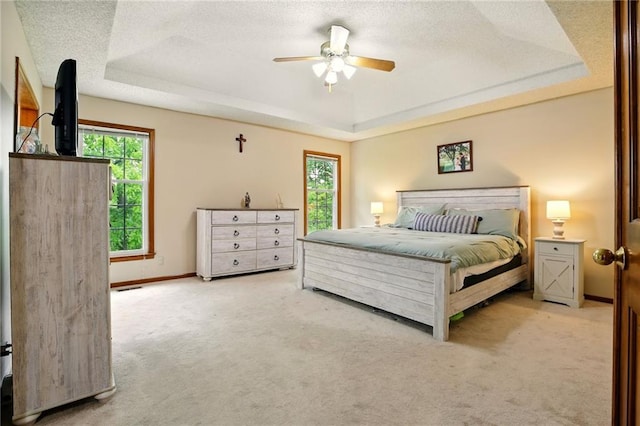 12844 Granada Ln, Leawood, KS 66209 - bedroom with a raised ceiling, multiple windows, carpet, a textured ceiling, and a ceiling fan
