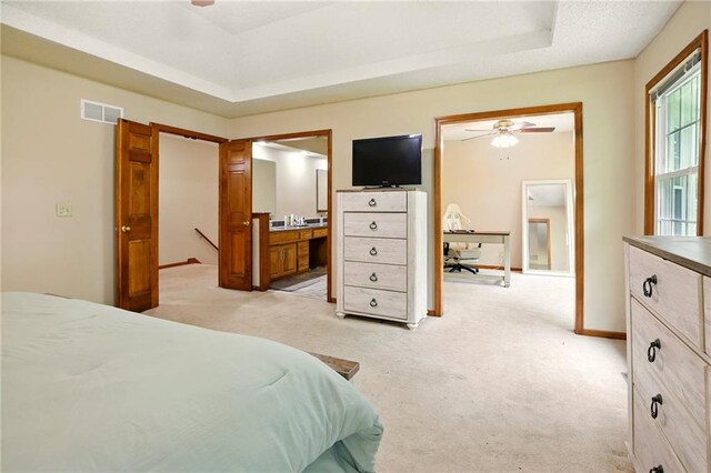 12844 Granada Ln, Leawood, KS 66209 - bedroom with light carpet, a tray ceiling, ensuite bathroom, and ceiling fan