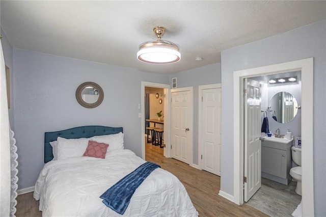 3802 Roanoke Rd, Kansas City, MO 64111 - bedroom featuring wood finished floors, a sink, baseboards, and ensuite bathroom