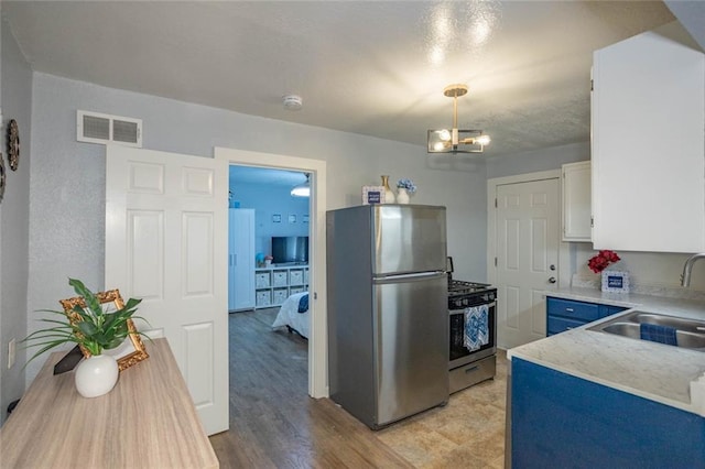 3802 Roanoke Rd, Kansas City, MO 64111 - kitchen featuring stainless steel appliances, a sink, light countertops, white cabinets, and a chandelier