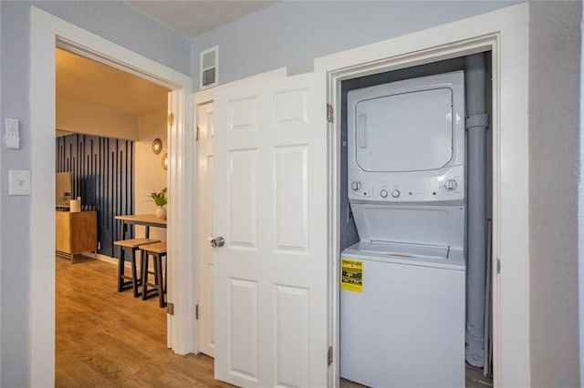 3802 Roanoke Rd, Kansas City, MO 64111 - laundry room featuring stacked washer / drying machine and wood finished floors
