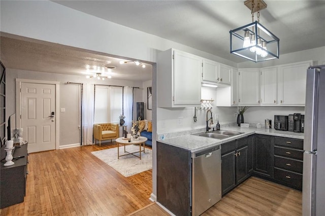3802 Roanoke Rd, Kansas City, MO 64111 - kitchen featuring stainless steel appliances, a sink, light wood-style floors, and white cabinets