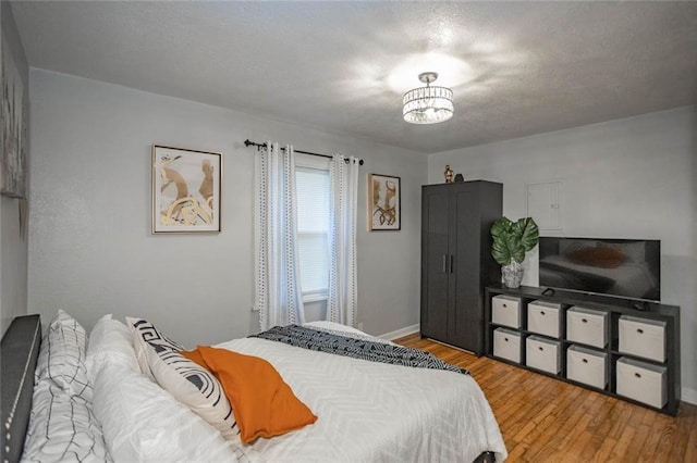 3802 Roanoke Rd, Kansas City, MO 64111 - bedroom with wood finished floors, baseboards, and a chandelier