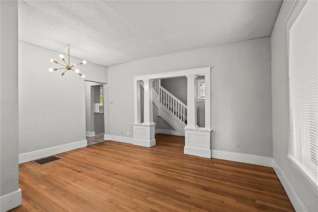 509 Pottawatomie St, Leavenworth, KS 66048 - unfurnished room featuring a chandelier, wood finished floors, a textured ceiling, and stairway
