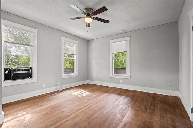 509 Pottawatomie St, Leavenworth, KS 66048 - empty room with plenty of natural light, wood finished floors, ceiling fan, cooling unit, and a textured ceiling