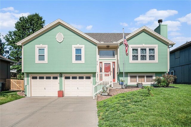 212 Hampton Dr, Smithville, MO 64089 - bi-level home with concrete driveway, an attached garage, and a chimney