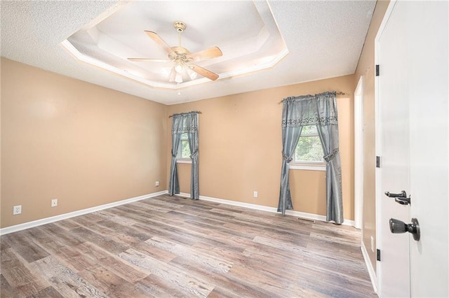 212 Hampton Dr, Smithville, MO 64089 - spare room with a tray ceiling, a ceiling fan, wood finished floors, and a textured ceiling