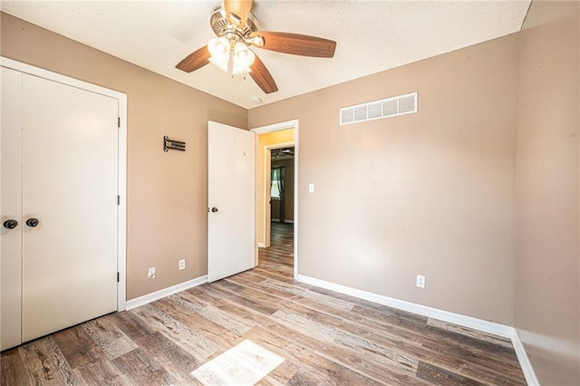 212 Hampton Dr, Smithville, MO 64089 - unfurnished bedroom with wood finished floors and ceiling fan