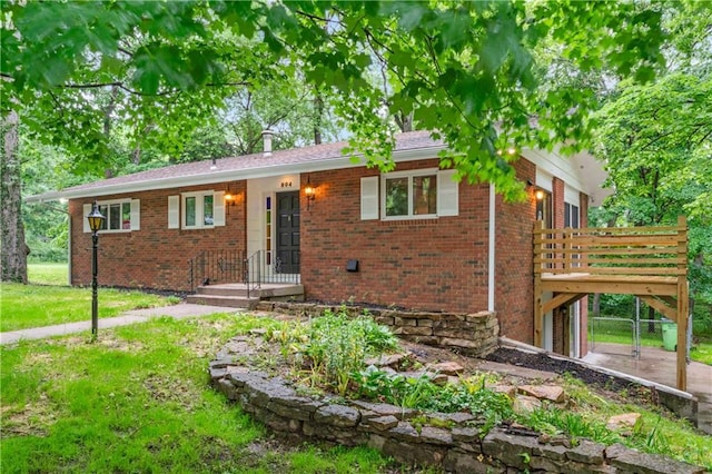 804 5th St, Baldwin City, KS 66006 - ranch-style home with brick siding, a wooden deck, and a front lawn