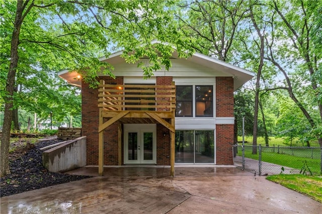 804 5th St, Baldwin City, KS 66006 - rear view of property with french doors, brick siding, and a patio area