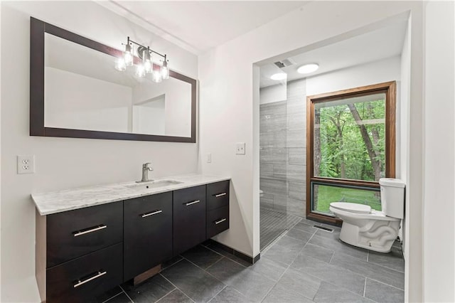 804 5th St, Baldwin City, KS 66006 - bathroom with toilet, vanity, tiled shower, baseboards, and tile patterned flooring