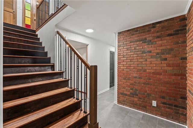 804 5th St, Baldwin City, KS 66006 - stairs with brick wall, tile patterned flooring, and baseboards