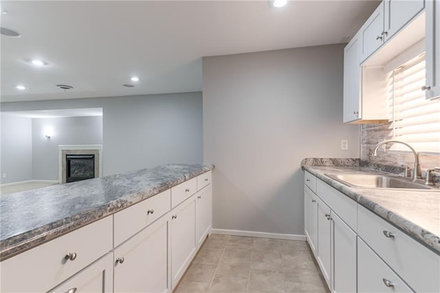 13310 W 129th St, Overland Park, KS 66213 - kitchen featuring a sink, a fireplace, recessed lighting, baseboards, and white cabinets