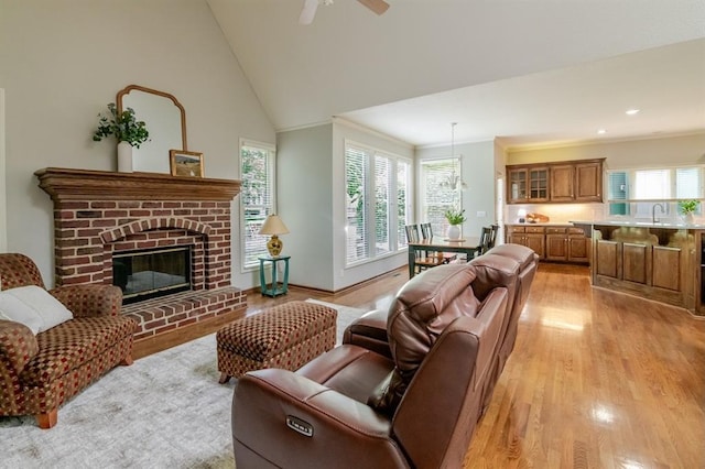 13310 W 129th St, Overland Park, KS 66213 - living area with light wood-type flooring, crown molding, a brick fireplace, a ceiling fan, and vaulted ceiling