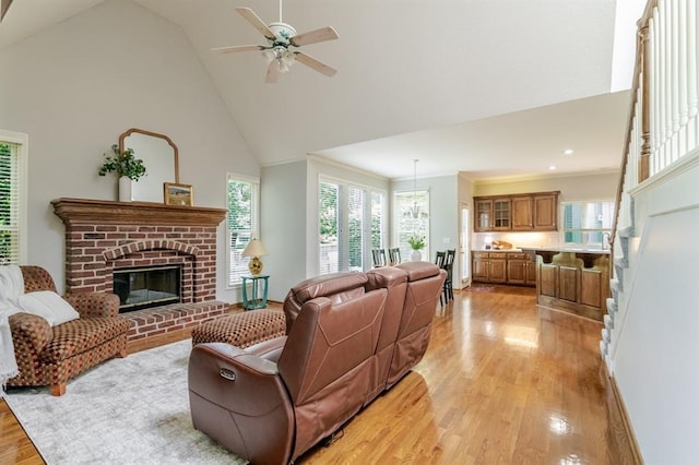 13310 W 129th St, Overland Park, KS 66213 - living room with high vaulted ceiling, light wood-type flooring, a brick fireplace, plenty of natural light, and ceiling fan
