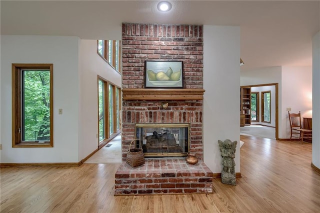 5317 NW Bluff Way, Parkville, MO 64152 - living room with plenty of natural light, wood finished floors, a brick fireplace, and baseboards