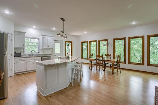 5317 NW Bluff Way, Parkville, MO 64152 - kitchen with a center island, a sink, light wood-style floors, light stone countertops, and appliances with stainless steel finishes