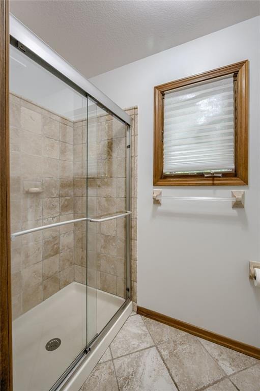 5317 NW Bluff Way, Parkville, MO 64152 - bathroom featuring a shower stall, baseboards, and a textured ceiling