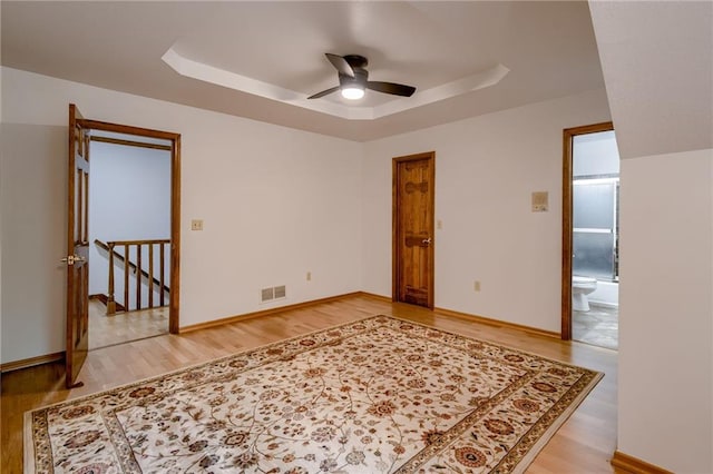5317 NW Bluff Way, Parkville, MO 64152 - spare room featuring a tray ceiling, light wood finished floors, and ceiling fan