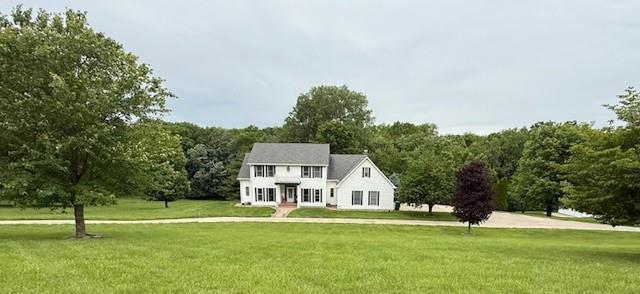 5604 Pleasant Ave, Saint Joseph, MO 64503 - colonial-style house featuring a front yard and a wooded view
