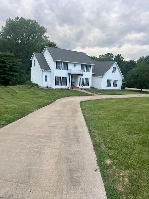 5604 Pleasant Ave, Saint Joseph, MO 64503 - colonial inspired home featuring a front lawn, concrete driveway, and a balcony