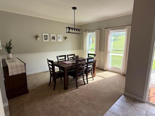 5604 Pleasant Ave, Saint Joseph, MO 64503 - dining area featuring light colored carpet, ornamental molding, baseboards, and light tile patterned floors