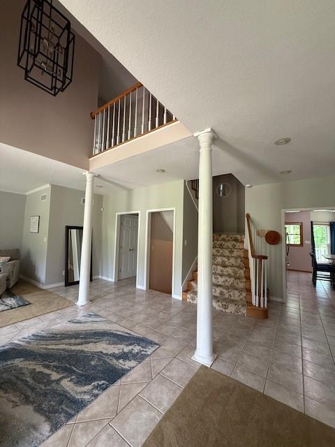 5604 Pleasant Ave, Saint Joseph, MO 64503 - staircase featuring decorative columns, tile patterned flooring, and baseboards