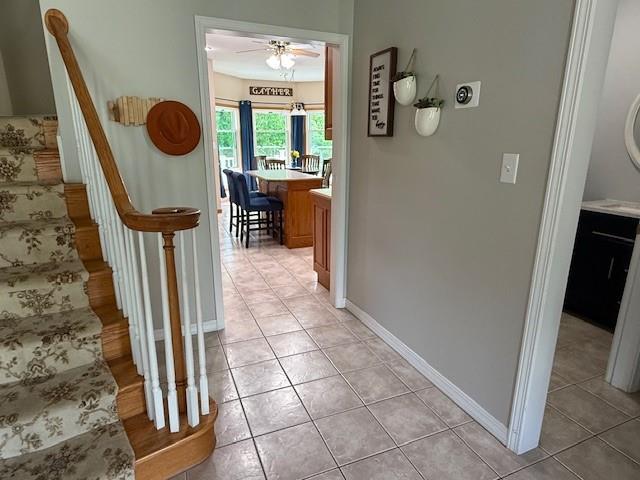 5604 Pleasant Ave, Saint Joseph, MO 64503 - hallway featuring stairs, light tile patterned floors, and baseboards