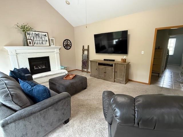5604 Pleasant Ave, Saint Joseph, MO 64503 - living area featuring lofted ceiling, baseboards, a brick fireplace, and light carpet