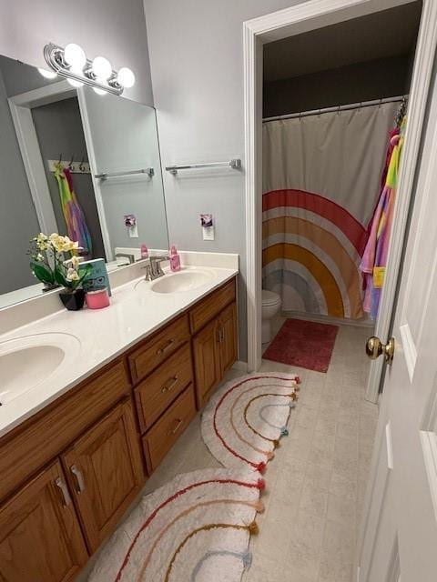 5604 Pleasant Ave, Saint Joseph, MO 64503 - full bathroom with double vanity, toilet, and a shower with shower curtain