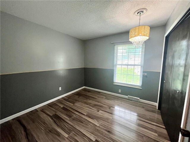 1 N Vine View St, Platte City, MO 64079 - empty room featuring wood finished floors, a textured ceiling, a chandelier, and baseboards