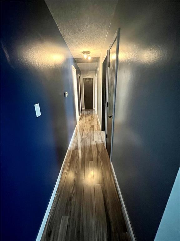 1 N Vine View St, Platte City, MO 64079 - hallway with a textured ceiling, wood finished floors, and baseboards