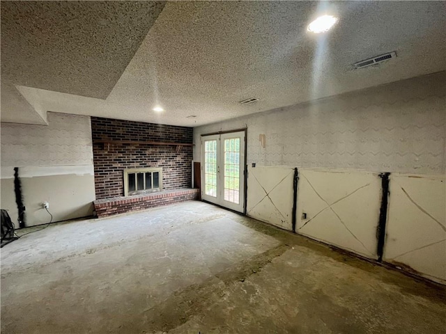1 N Vine View St, Platte City, MO 64079 - unfurnished living room with unfinished concrete flooring, a fireplace, and a textured ceiling