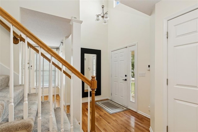 15050 W 145th St, Olathe, KS 66062 - entrance foyer with stairway, light wood-style flooring, baseboards, a high ceiling, and a chandelier